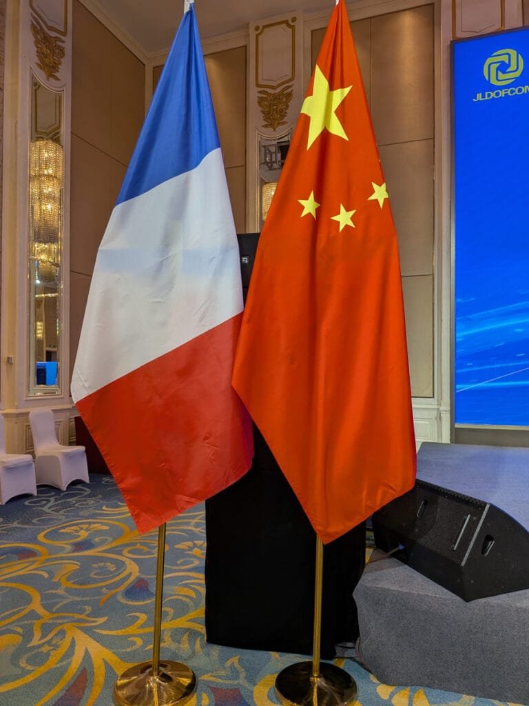 Photos des drapeaux français et chinois lors d'une réunion professionnelle en Chine avec la présence des canards volants, maison d'édition à l'origine de Thérébentine.